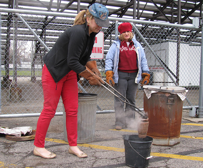 An IB art student places a raku-fired clay piece into water